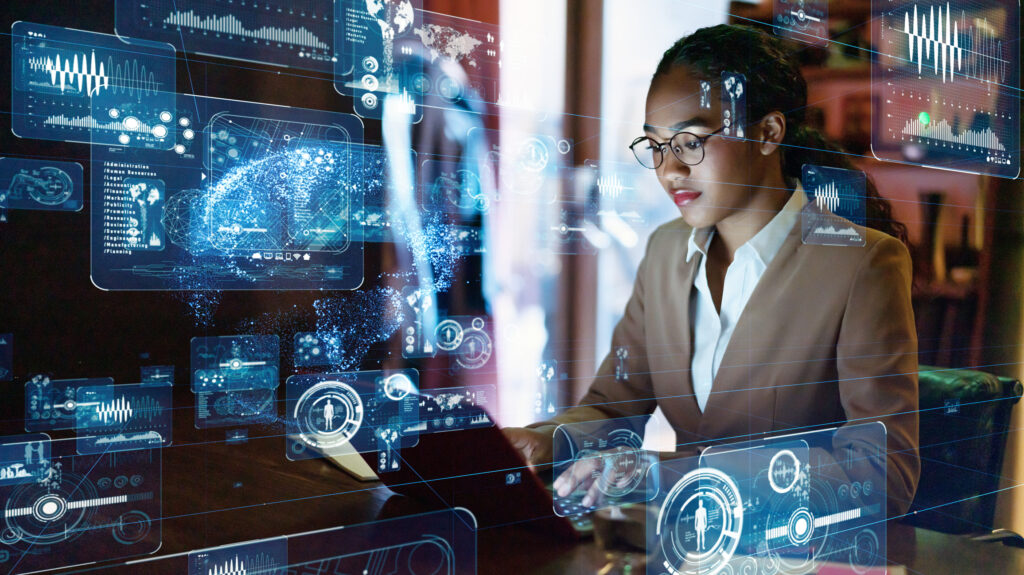 Mulherr negra usa óculos e usa laptop, o resto da imagem é preenchido com hologramas flutuantes de referências a tecnologia.
